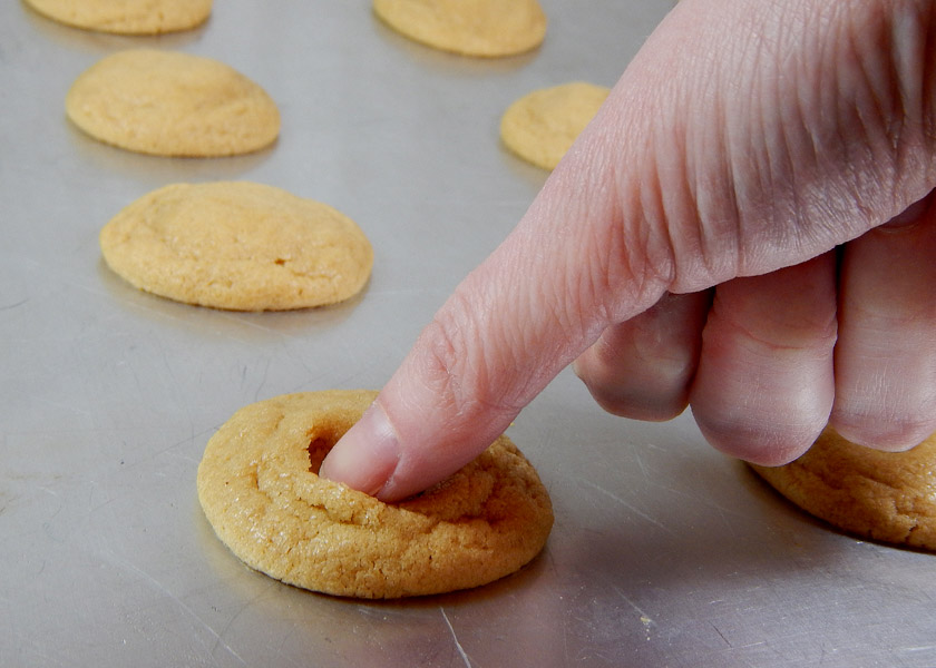 Making thumbrints in peanut butter cookies