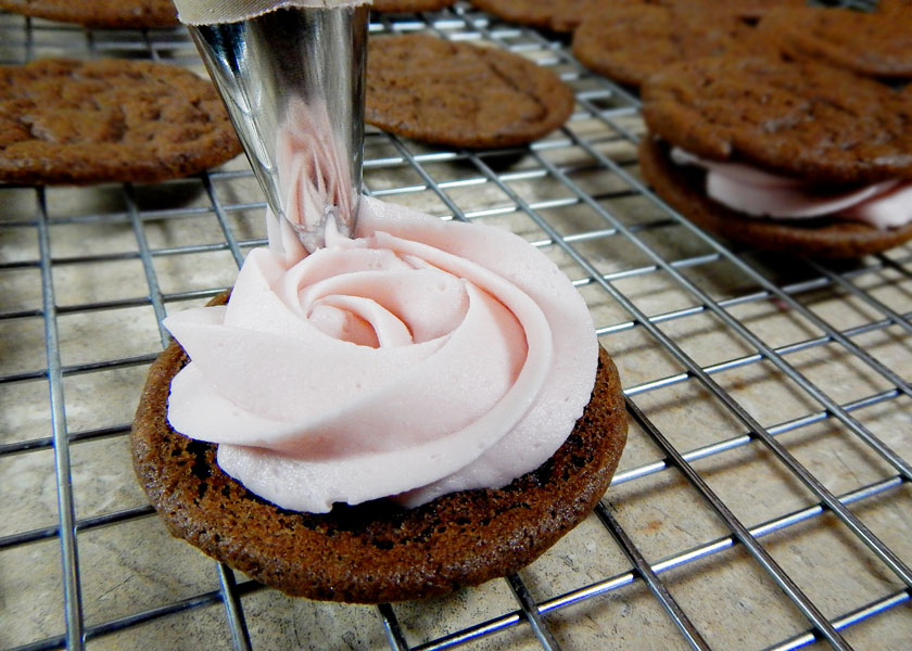 Piping  buttercream onto cookie