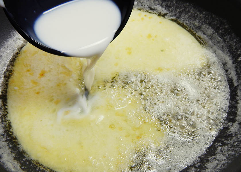 Milk, butter, and garlic cooking for mashed potato frosting