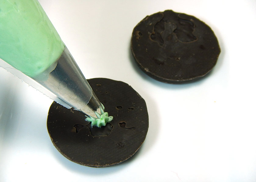 Piping Cheesecake onto Thin Mint Cookies