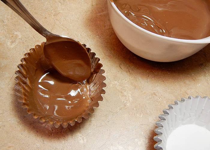 Spooning Chocolate Into A Foil Cupcake Wrapper