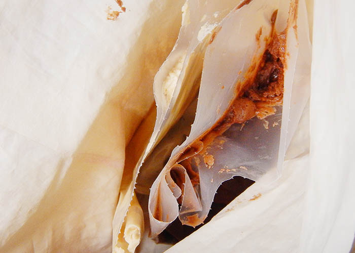 Two small pastry bags inside of a large pastry bag